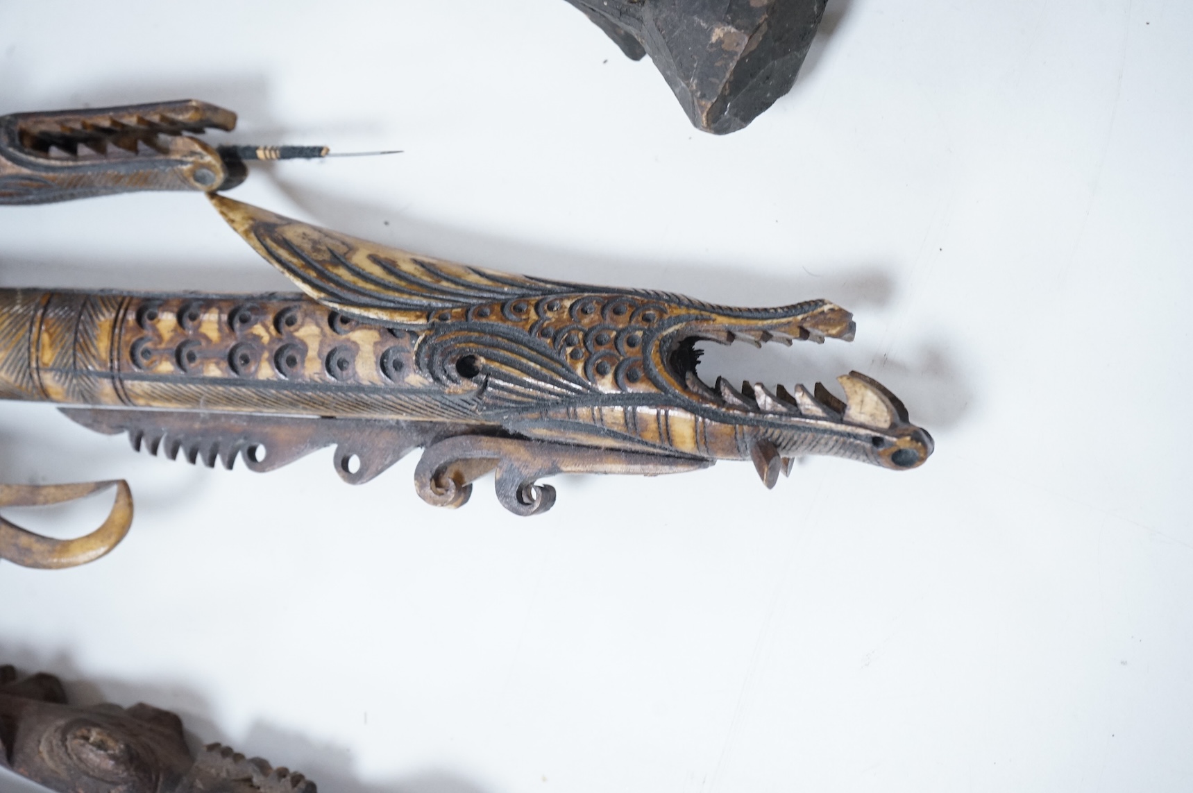 Two Papua New Guinea Sepik River carvings and a carved bone artefact, largest 92cm in length